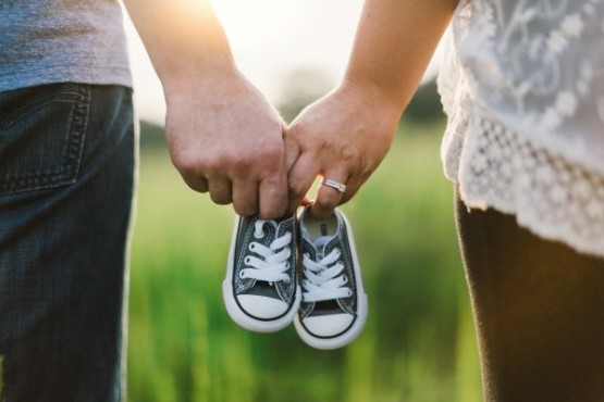 young-couple-holding-baby-shoes